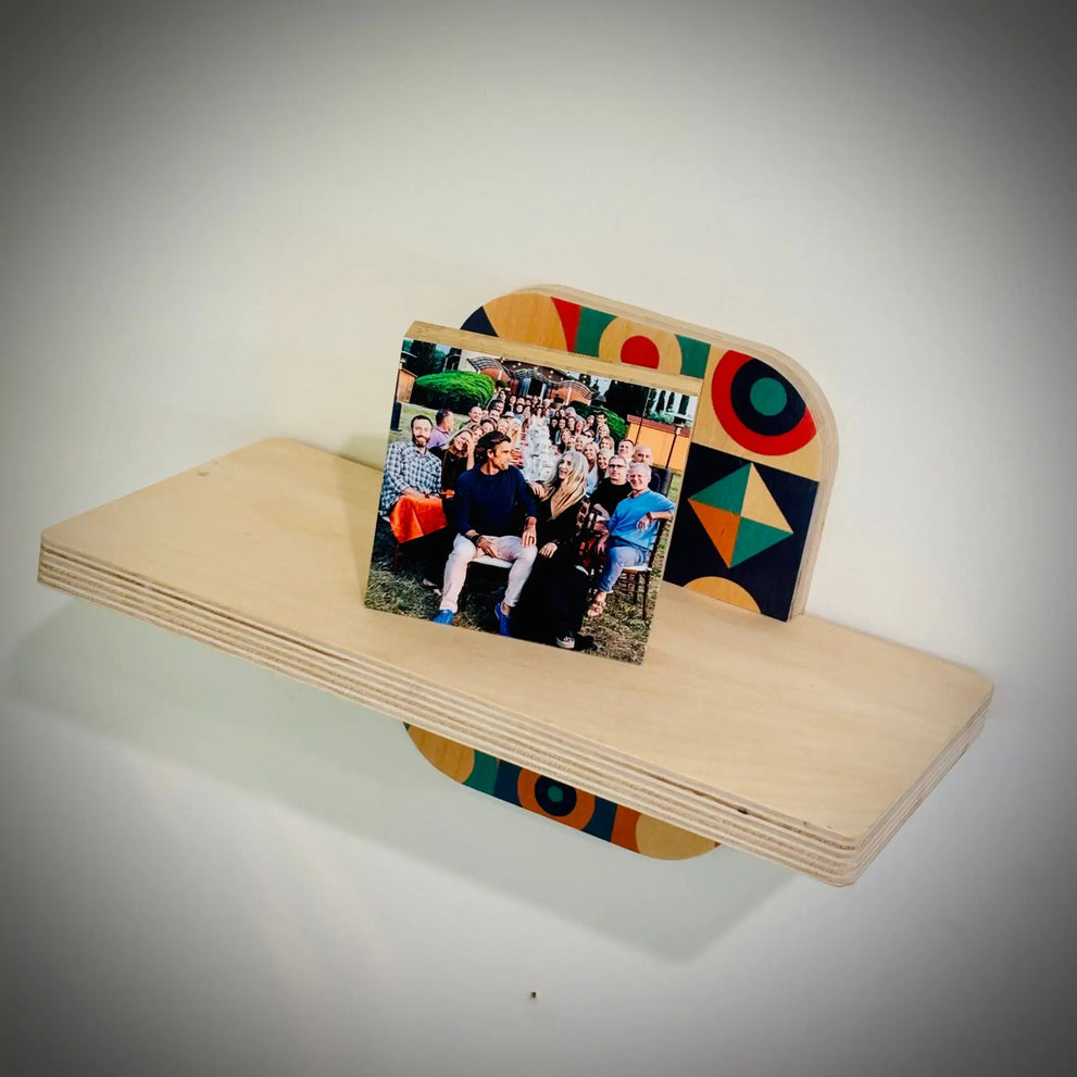 Light-colored wooden wall shelf with colorful support holding a photo in woodsnapsturdy style
