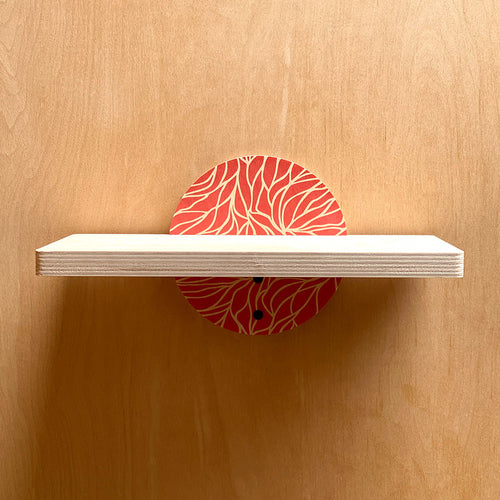 White wall shelf with coral patterned circular supports for a sturdy wall shelf display